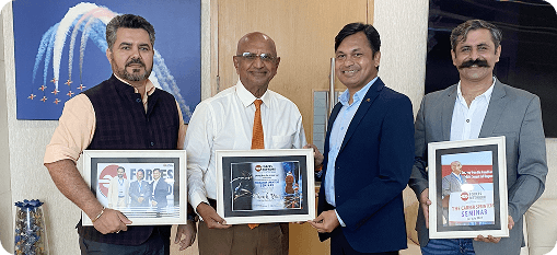 Captain Uday K. Shriwas standing with fellow professionals holding framed event mementos