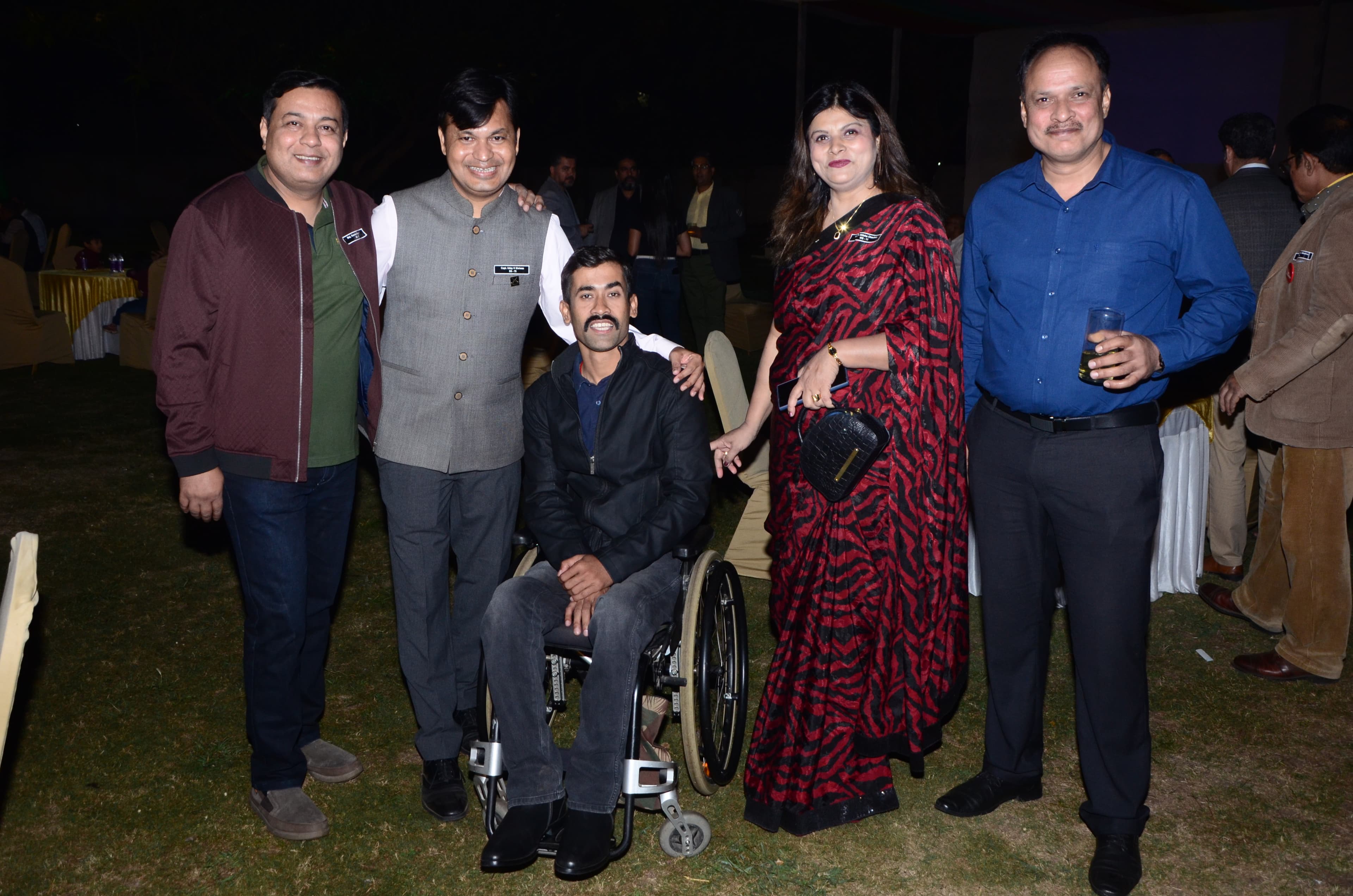 A small group of professionals standing together at an evening community gathering